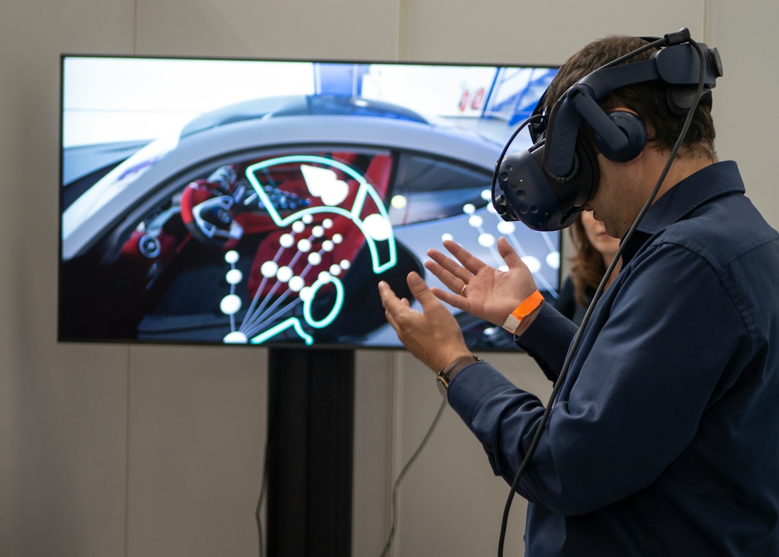 Man in VR glasses infront of a TV screen.