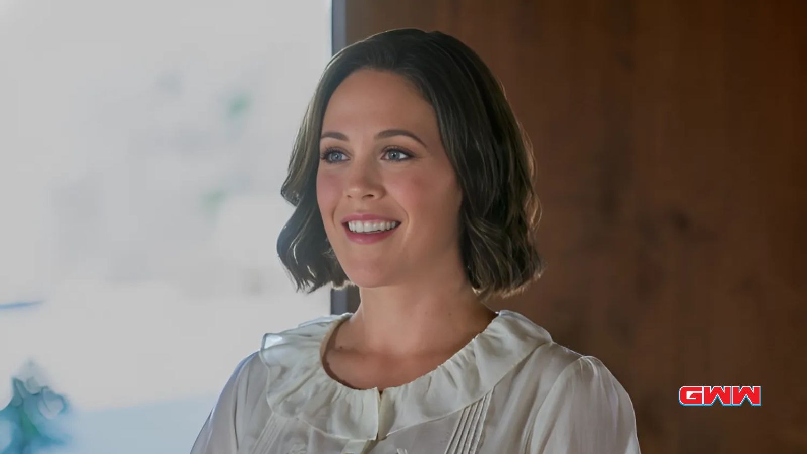 Elizabeth Thornton indoors, smiling warmly in a white blouse.