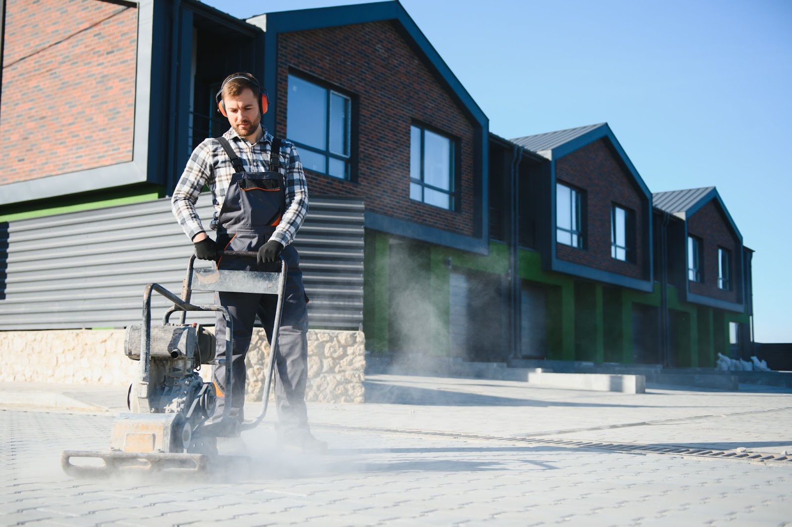 A professional paver laying paving stones for a residential driveway for multiple homes.