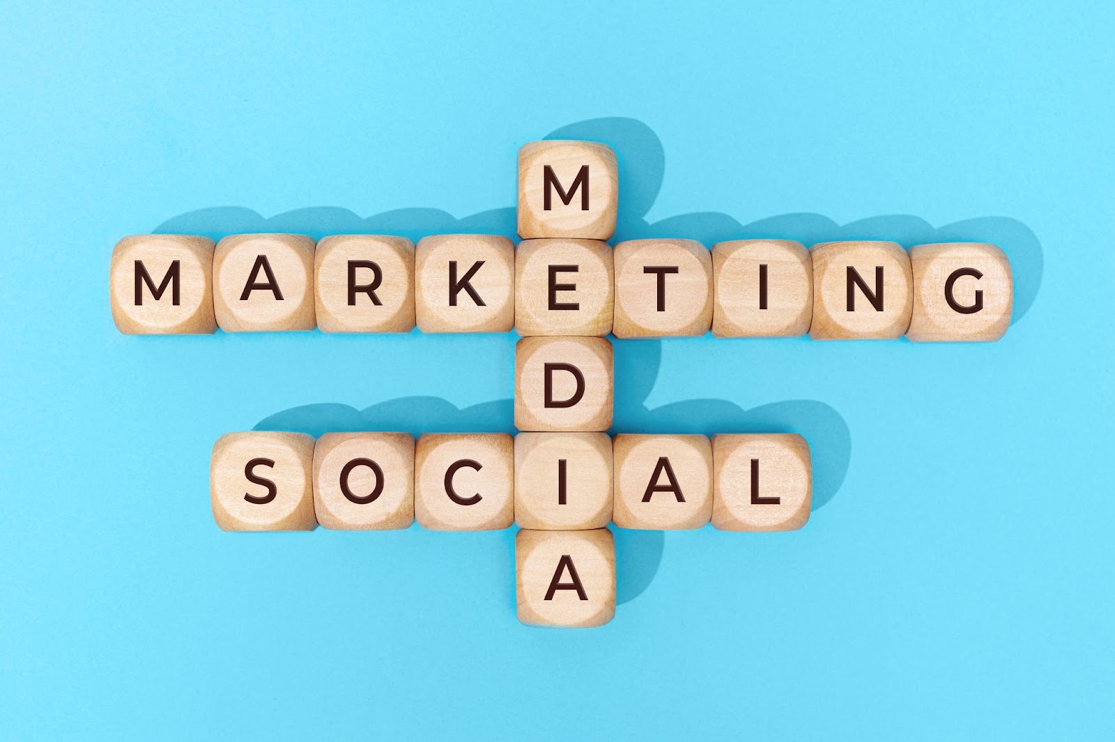 Interlocking of wooden blocks that have the words “social media marketing” on them. 