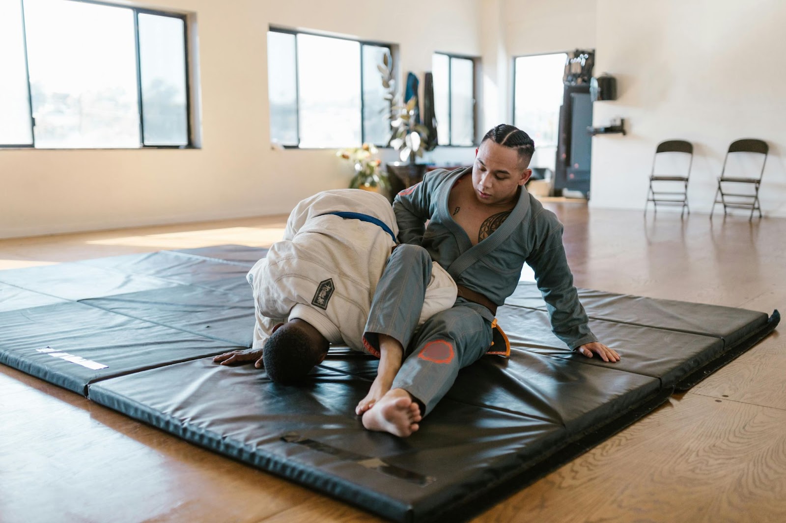 Two martial arts practitioners practicing ground takedowns and armlocks