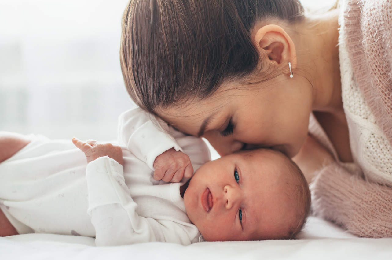 Mom kissing her infant // Healthier Baby Today