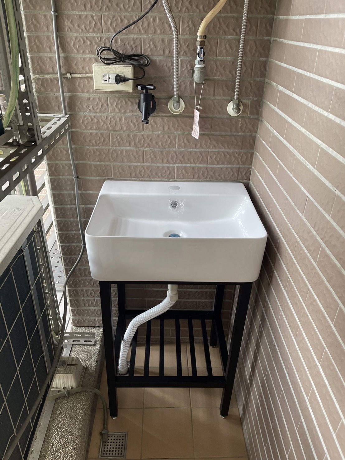 這是一個工業風黑色支架面盆組在工作陽台的情景