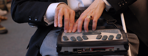 A visually impaired person using a keyboard for blind people that is integrated with assistive technology