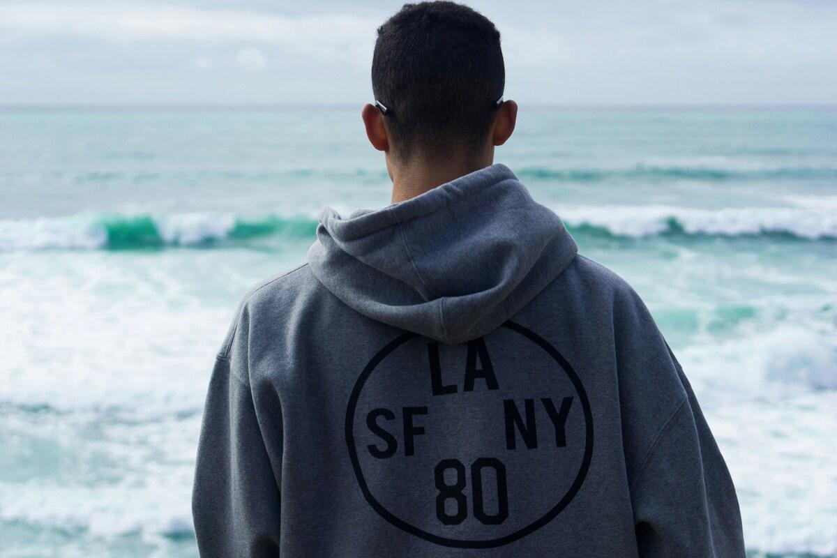 A person wearing a sweatshirt on the beach
