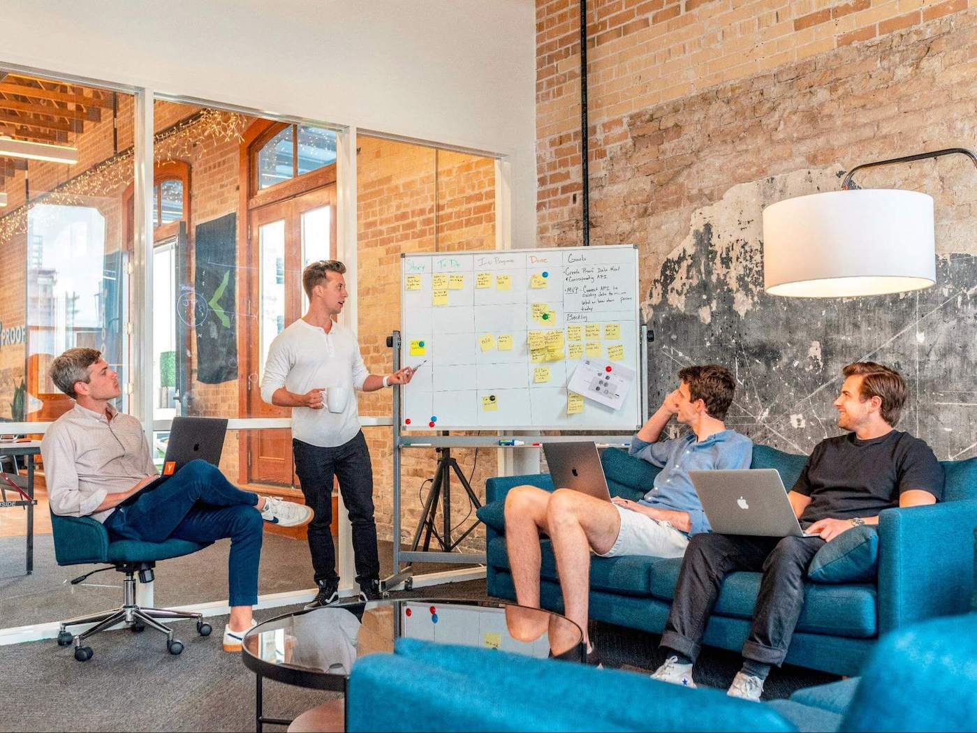 Four men in a meeting with a white board