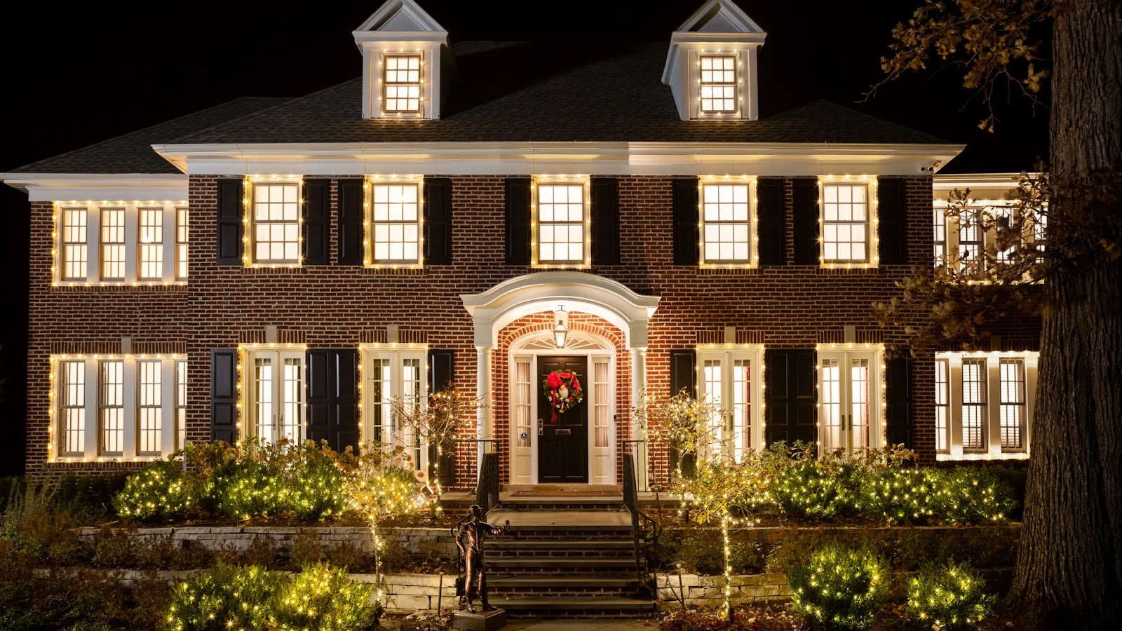 Fachada de la famosa casa de Mi Pobre Angelito, decorada con luces navideñas brillantes por la noche, con un diseño clásico y detalles elegantes.