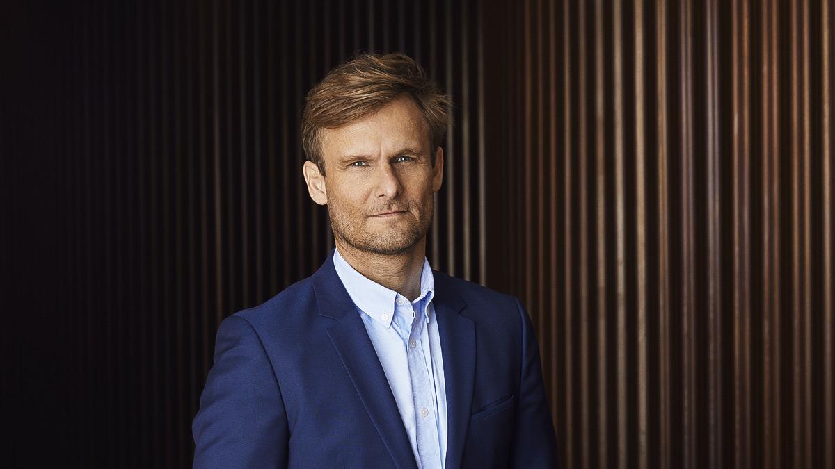 Dr Peter Holme Jensen, CEO and co-founder of Aquaporin, wearing navy blue suit, brown background