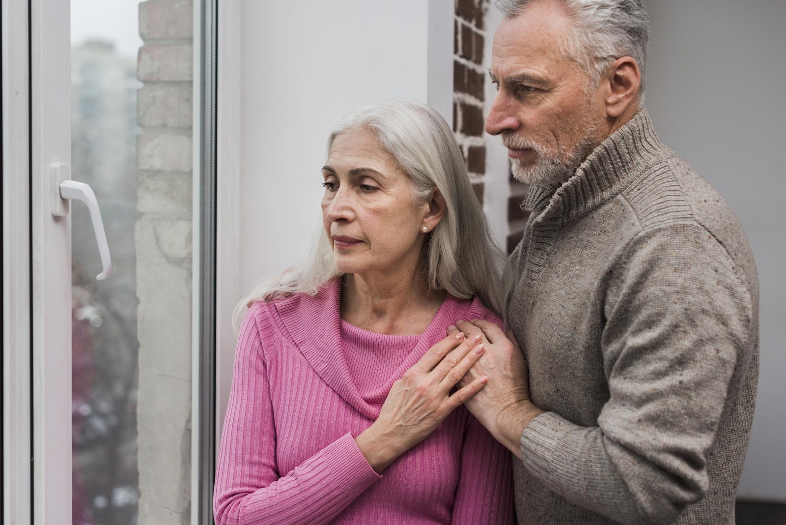 An elderly couple looking out the window | Source: Freepik