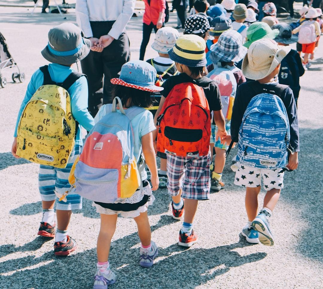 A group of children walking on the street<br />
<br />
Description automatically generated