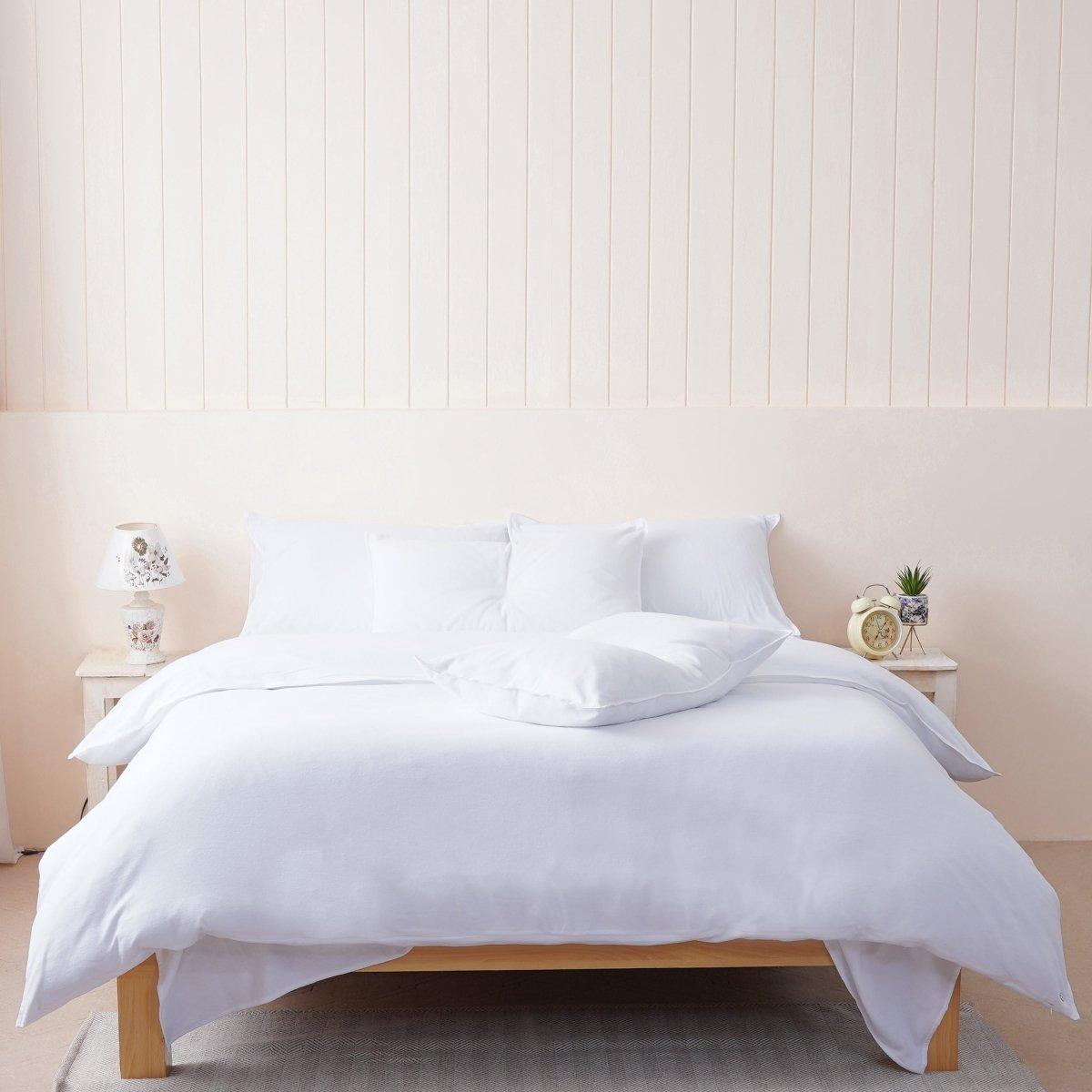 A bed with white sheets and pillows