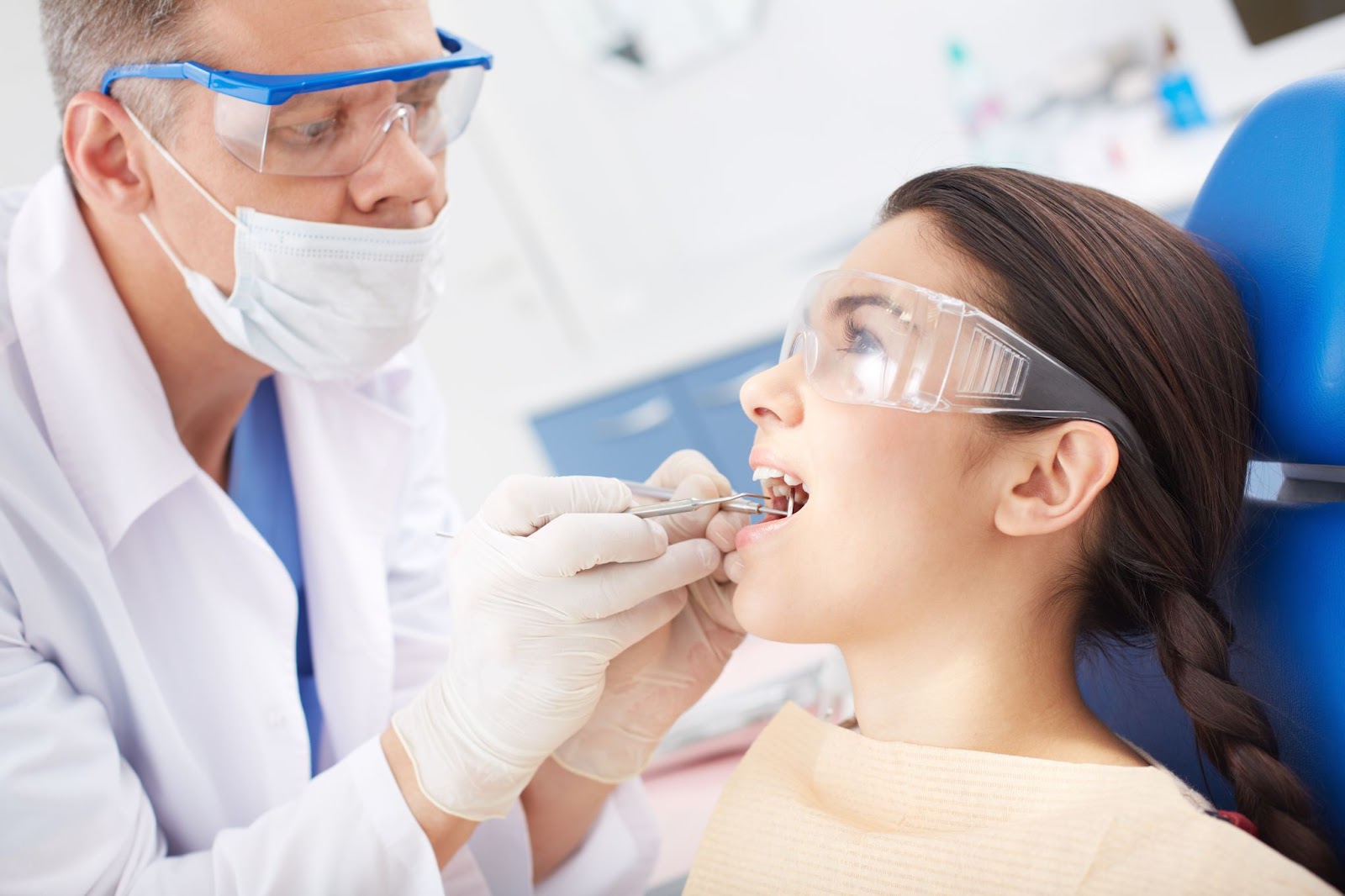 Dentist performing a detailed oral examination on a female patient to check for gum disease and oral health issues.