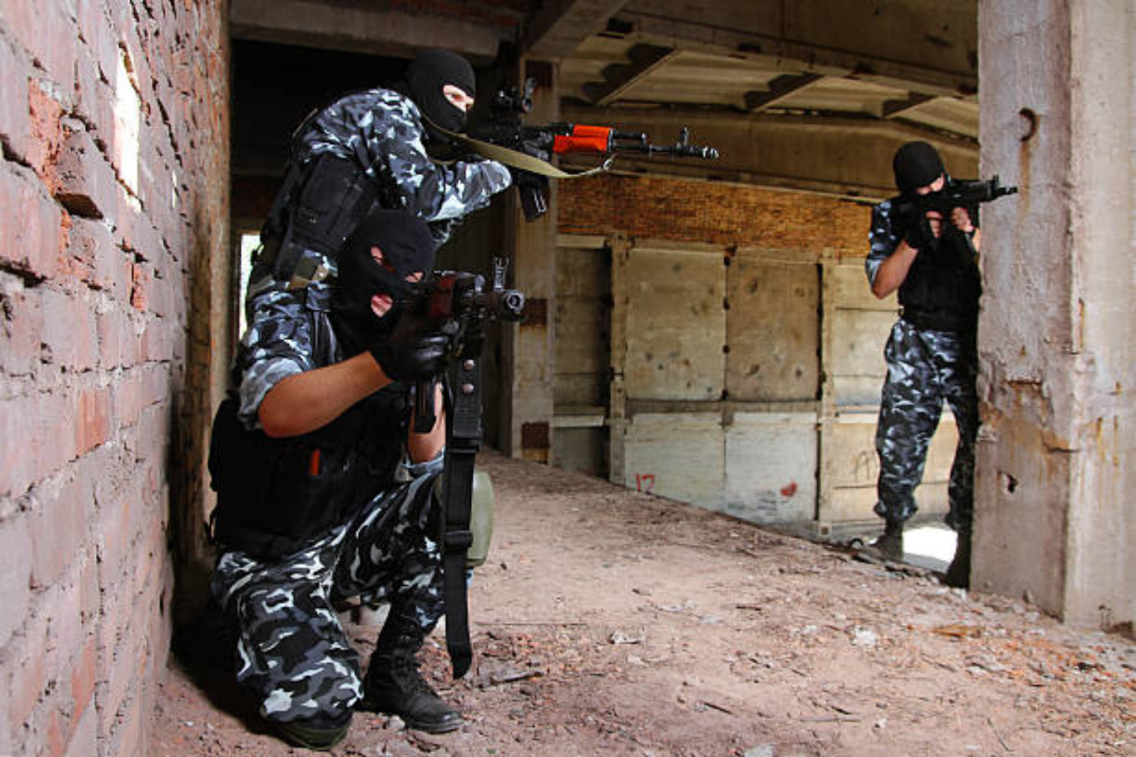 Three people are engaged in tactical shooting