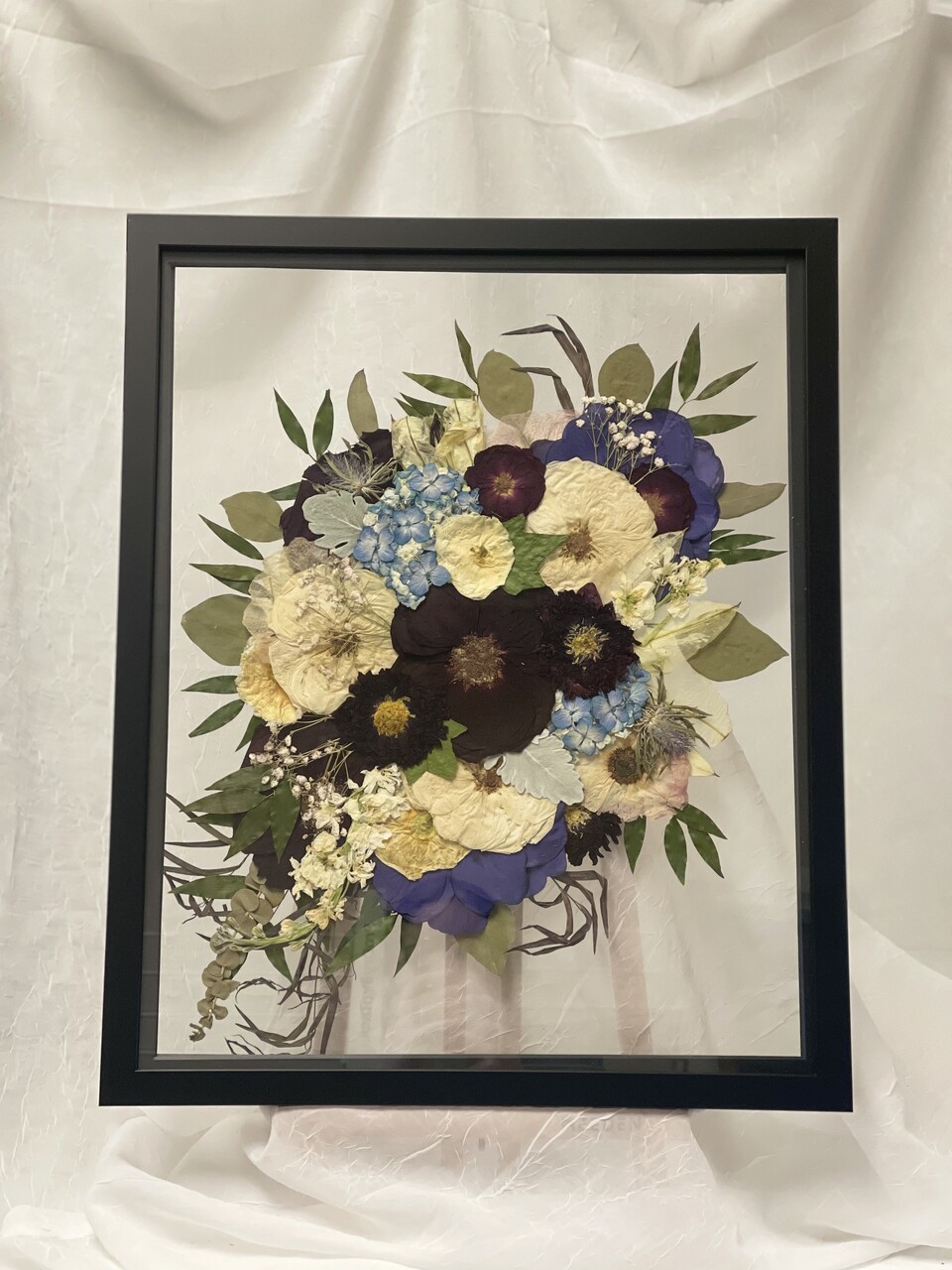 a large black frame with preserved flowers