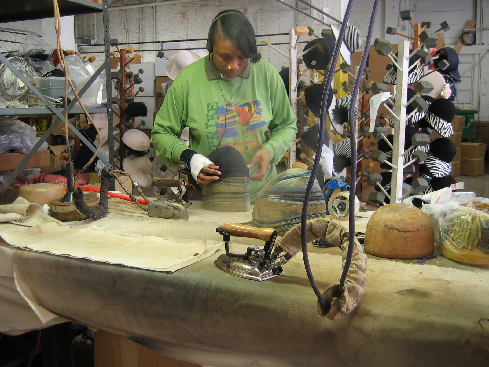 Lady steaming hats at MIO factory