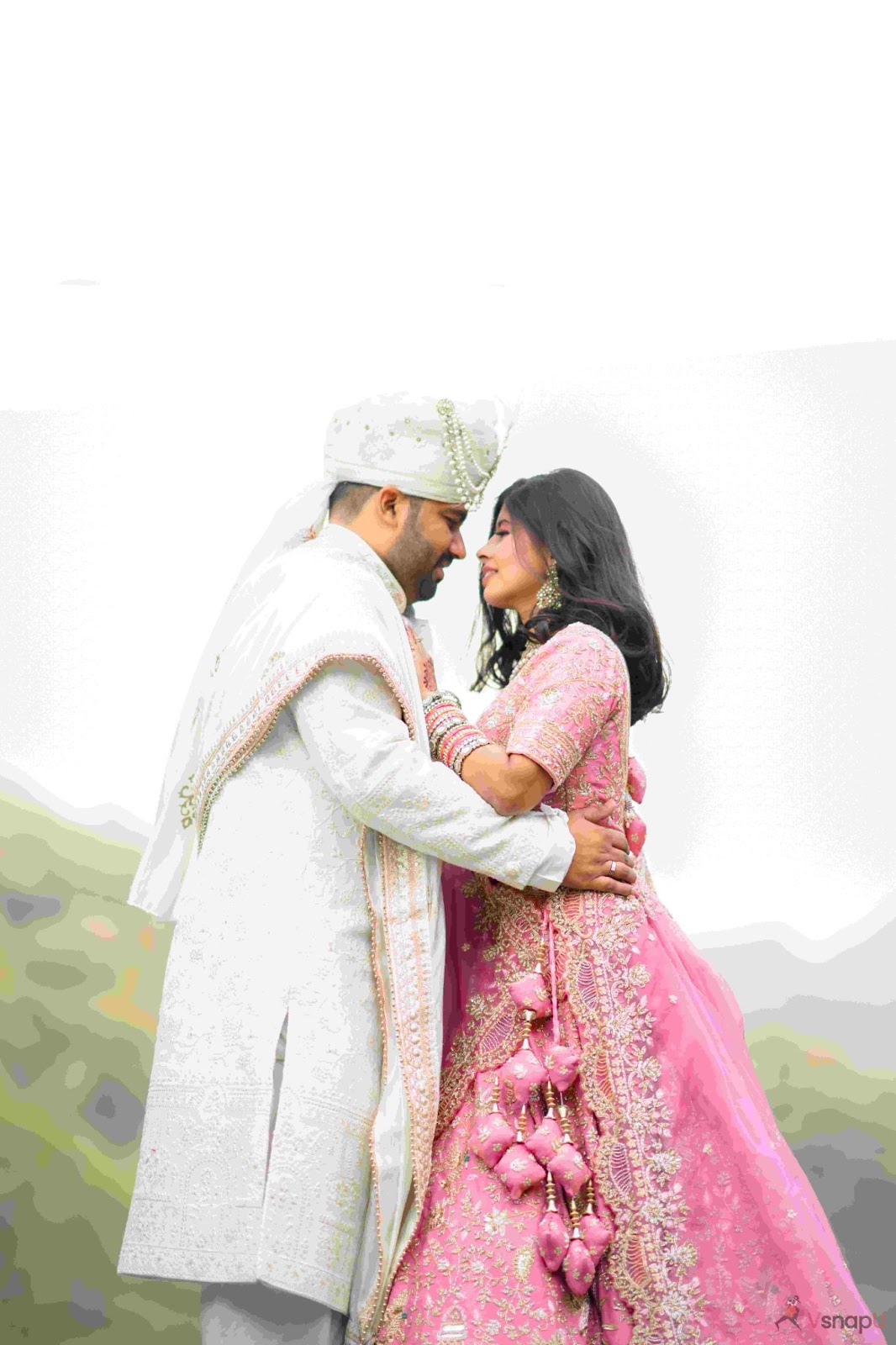 Couple sharing an intimate hug in the sunlight, capturing a beautiful candid moment on their wedding day.