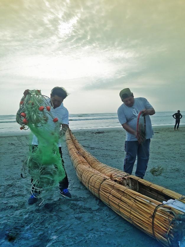 Dos hombres tirando de una red de pesca en una playa
Descripción generada automáticamente