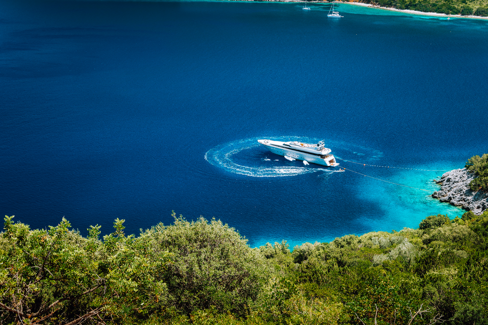 Luxury gulet anchored in a beautiful bay near Fethiye, with fashionable guests enjoying the deck