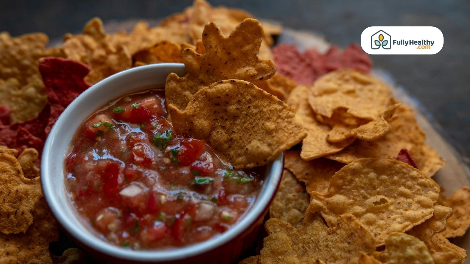 Fresh salsa surrounded by red and yellow tortilla chips