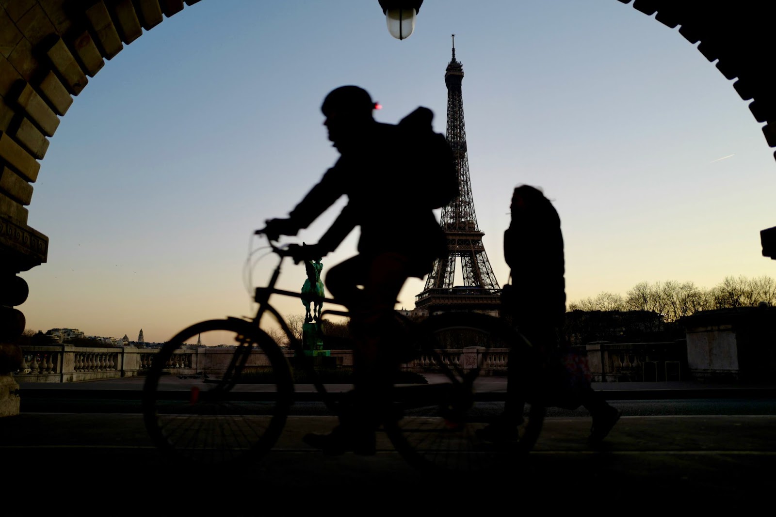 A visitor is strolling along the banks of the Seine on their rented electric bike after visiting Notre-Dame de Paris.