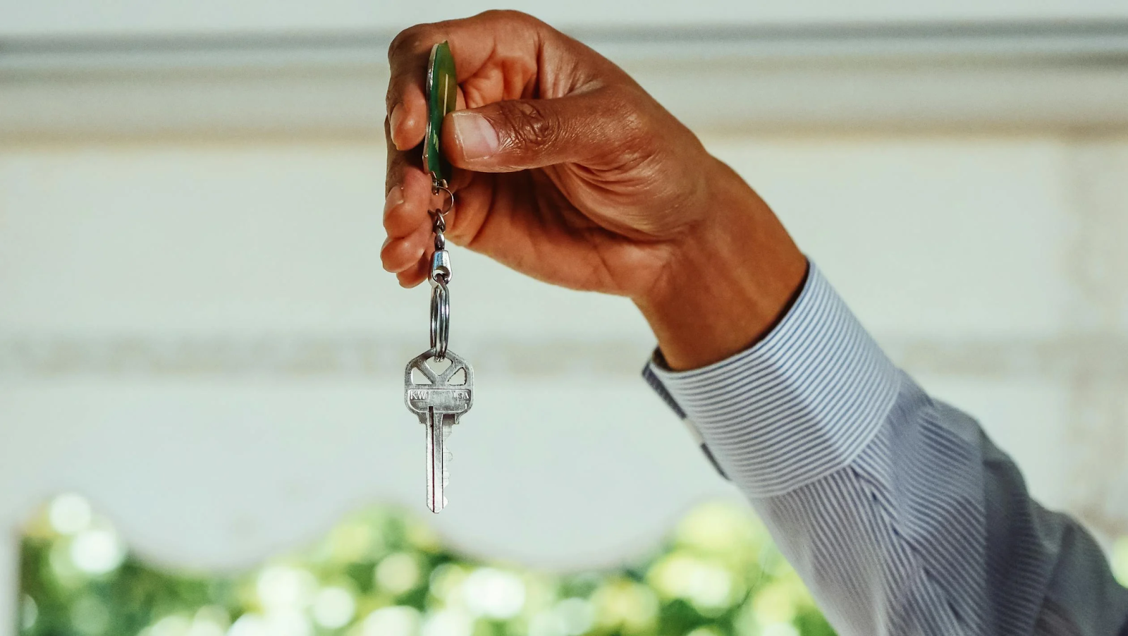 A hand holding a house key 