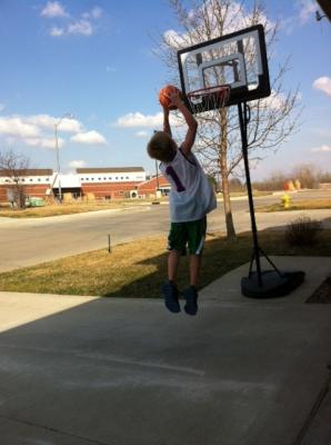 little kid attempting a dunk on a smaller hoop