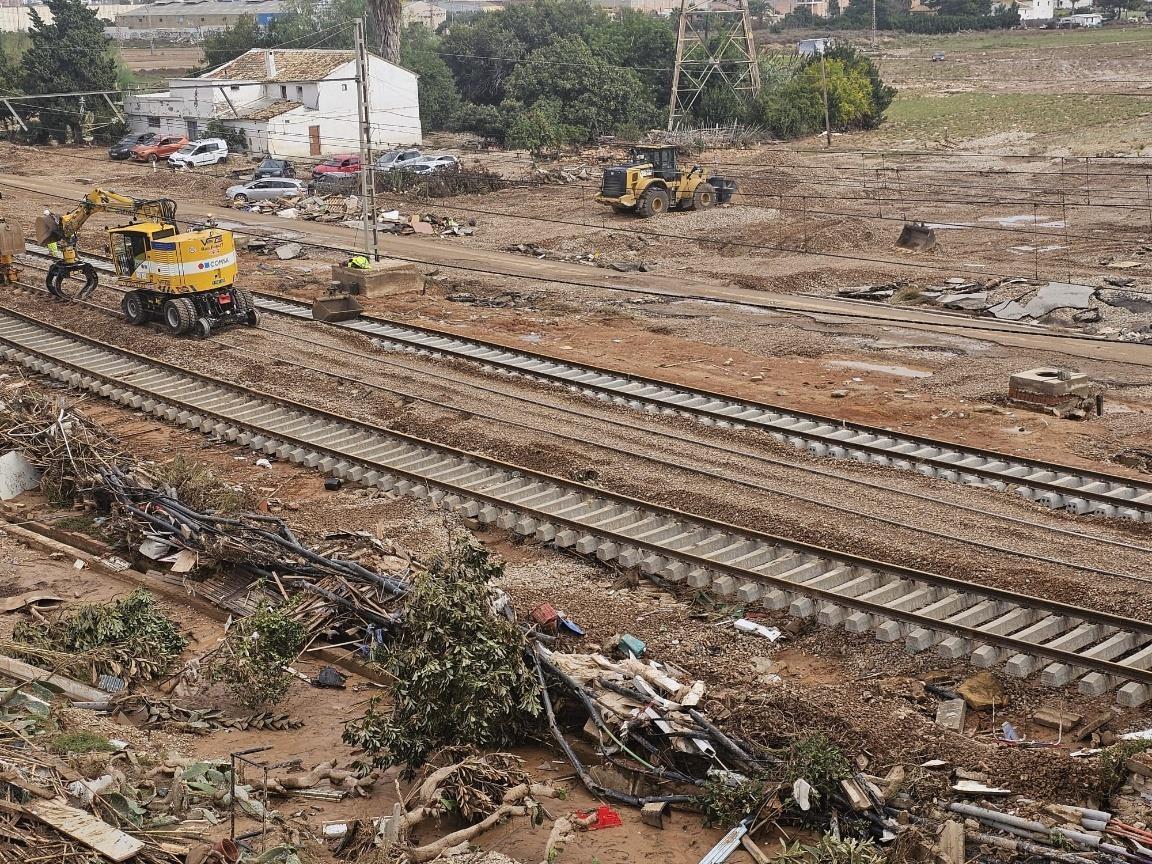 Tren de carga pasando por el campo  Descripción generada automáticamente