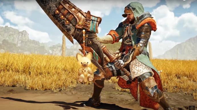 Cuplikan layar Monster Hunter Wilds yang memperlihatkan liontin versi beta terbuka eksklusif yang tergantung di pedang Hunter. Liontin itu menyerupai mainan berbulu halus dari Palico yang menyerupai kucing.