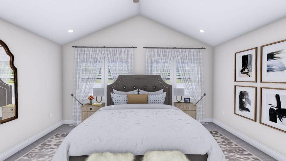 Primary bedroom with a cathedral ceiling and white walls graced with framed artworks and an arch mirror.