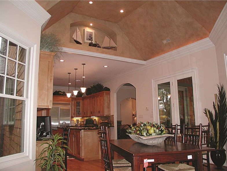 Breakfast nook with a wooden dining set and a coved ceiling fitted with an arched niche.