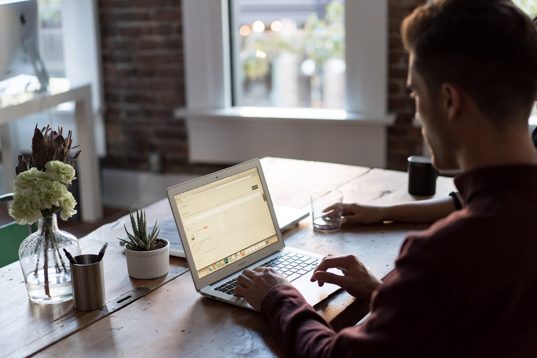 A person working at a desk with a laptop, utilizing an AI knowledge management system to streamline information processing.