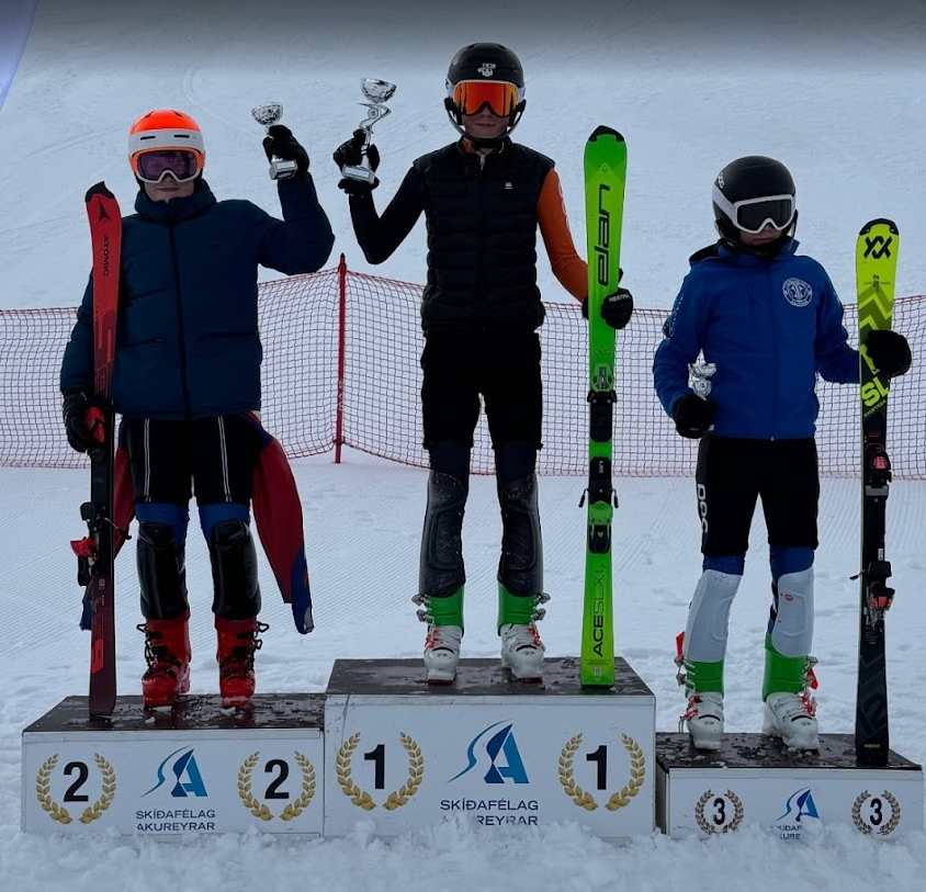 A group of people standing on a podium with skis and a trophy
AI-generated content may be incorrect.
