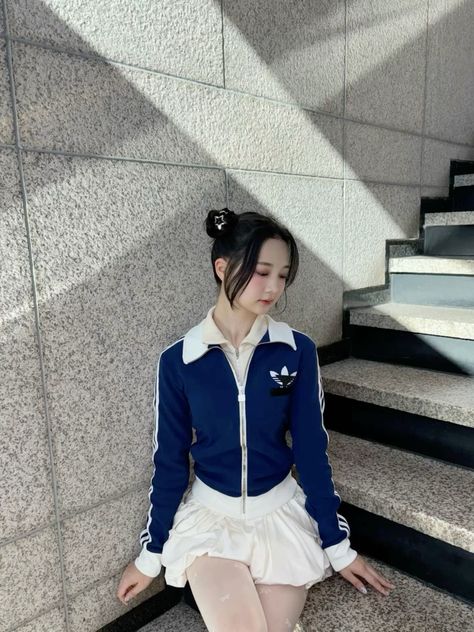  A picture of Madein Gaeun  on blue jacket and white shirt sitting on the star case