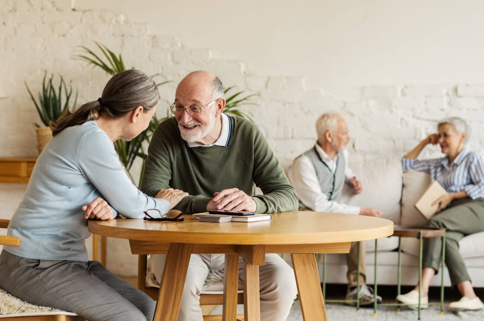 Older adults sitting in a common area in senior living socializing.