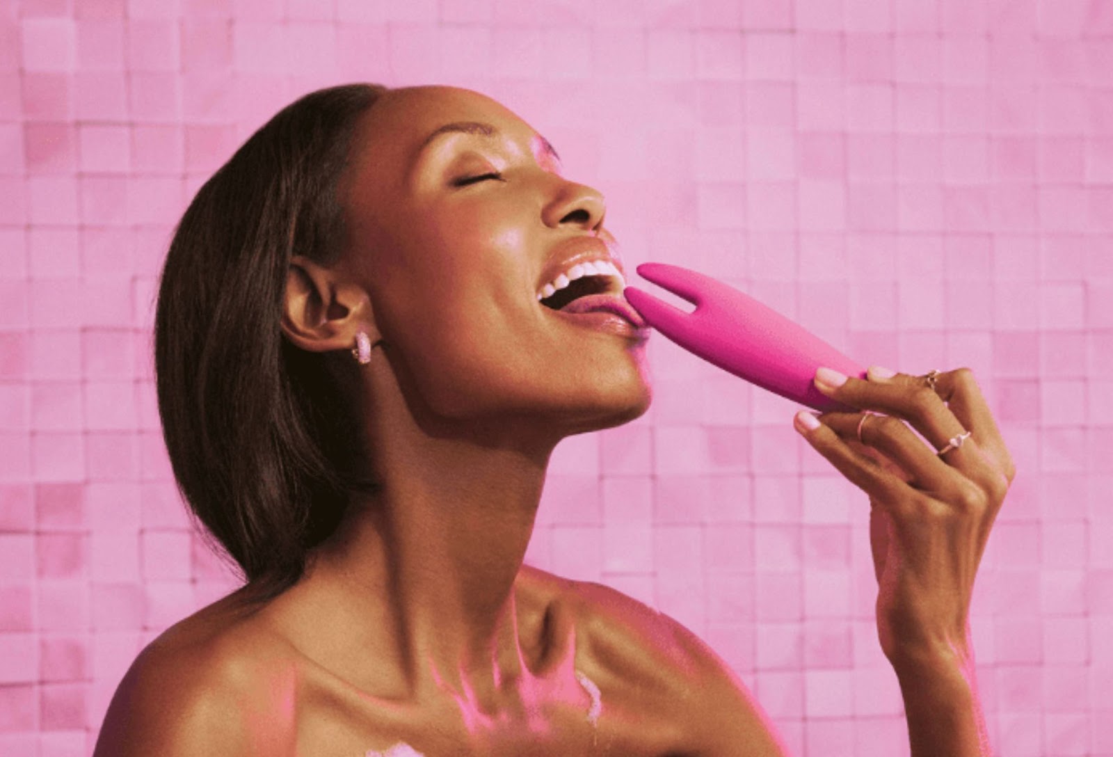 Mulher sorrindo encostando o vibrador língua da loveplay em sua língua