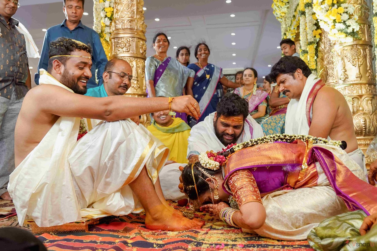 Emotional wedding moment as the bride seeks blessings from the groom in a traditional pose