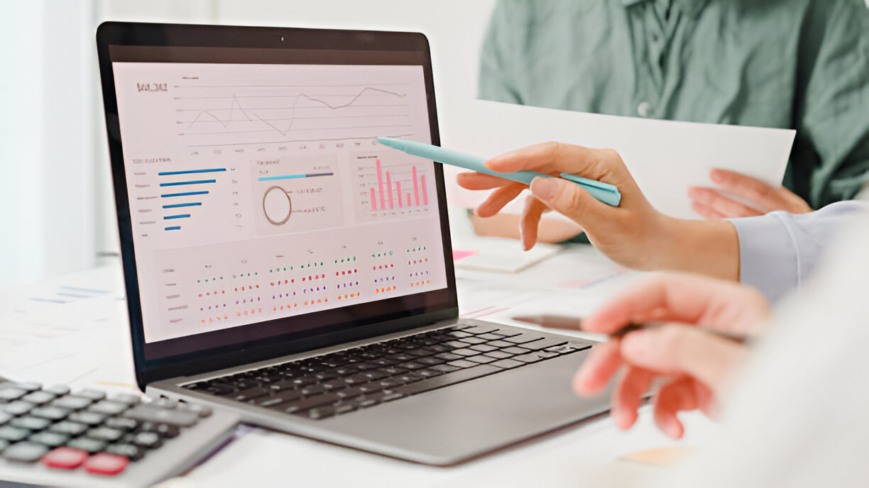 Team analyzing financial data on a laptop screen, illustrating how bookkeeping helps small businesses manage income, expenses, and financial records.