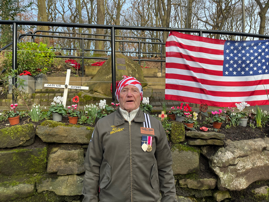 Plane crash witness, Tony Foulds, 88, standing in front of the memorial, wearing an Air Force jacket and an American Flag bandana on his head.