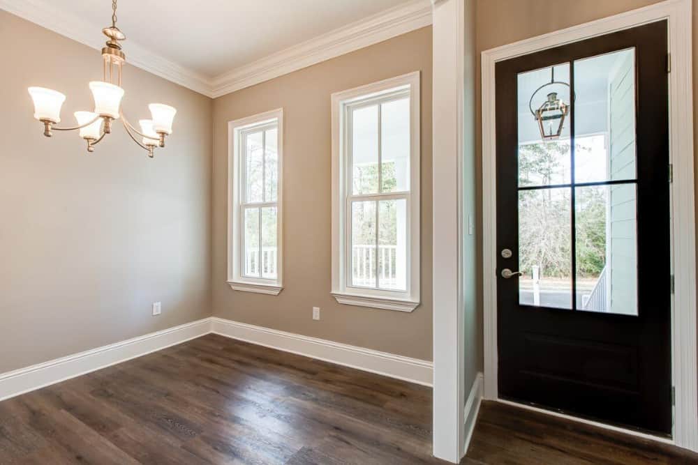 The foyer has a glazed entry door and it opens into a flex space warmed by a cozy chandelier.