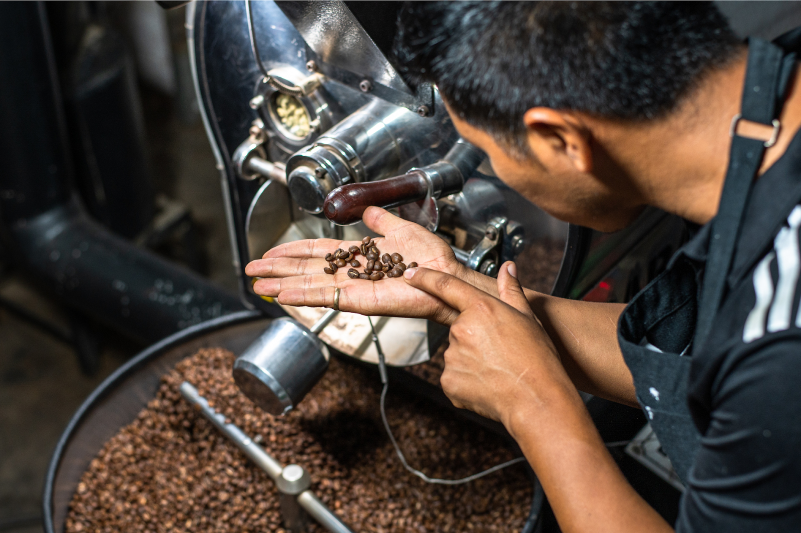 A picture of a man roasting large quantity of coffee