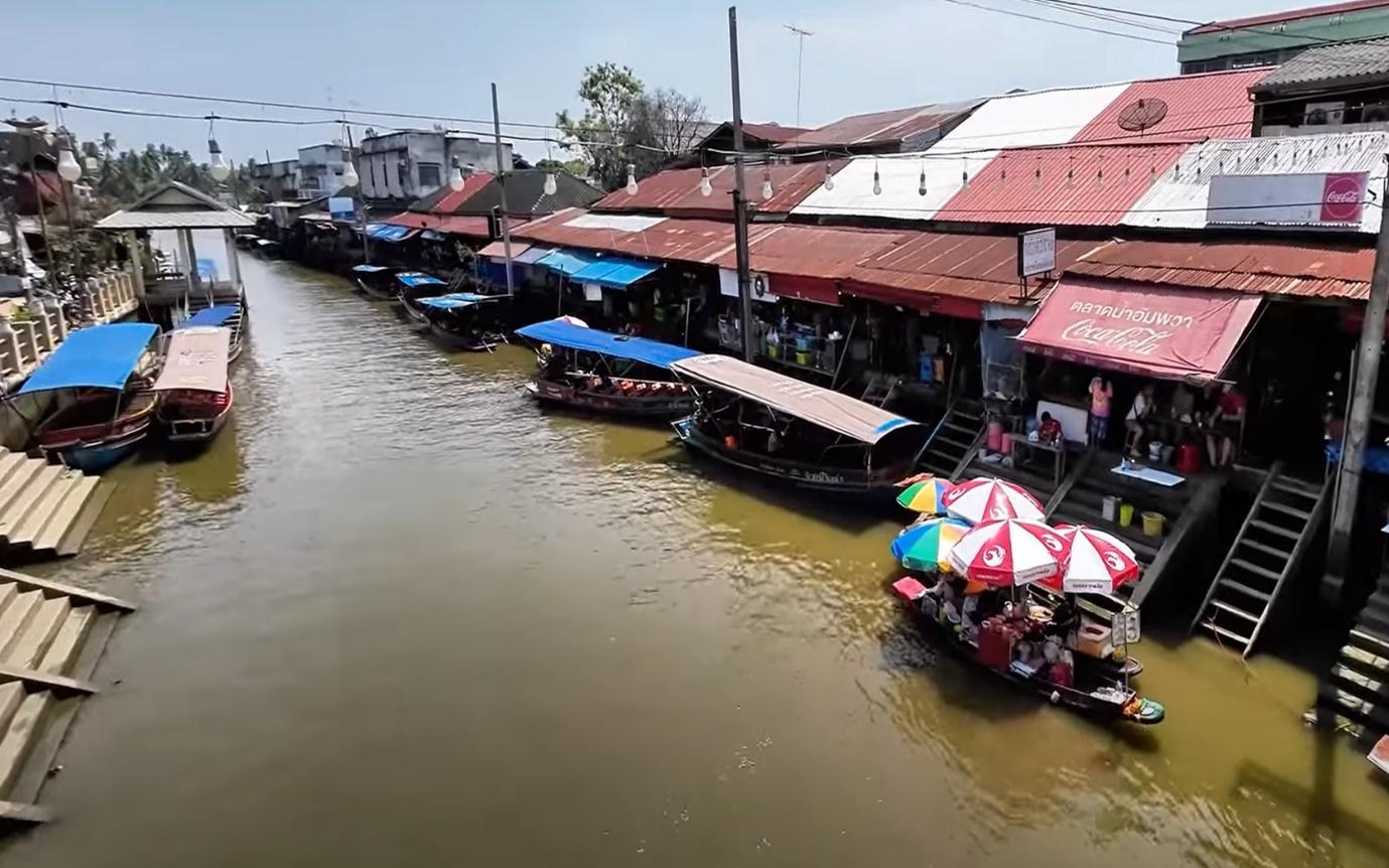 Boats on a river with many boats and umbrellas

Description automatically generated