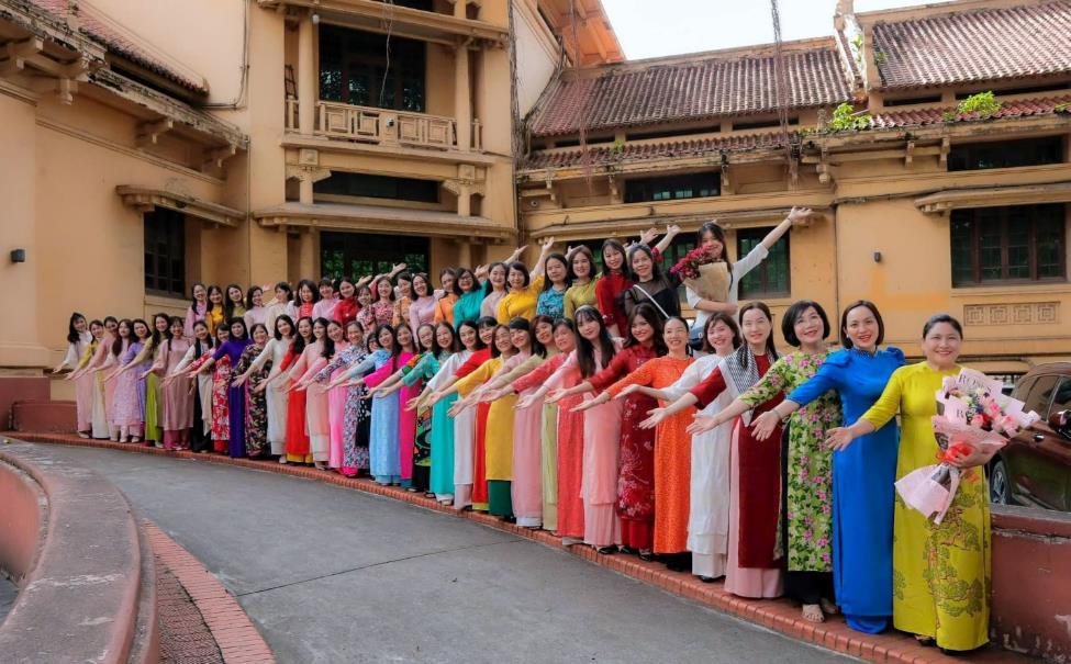 A group of women in colorful dresses posing for a photoDescription automatically generated