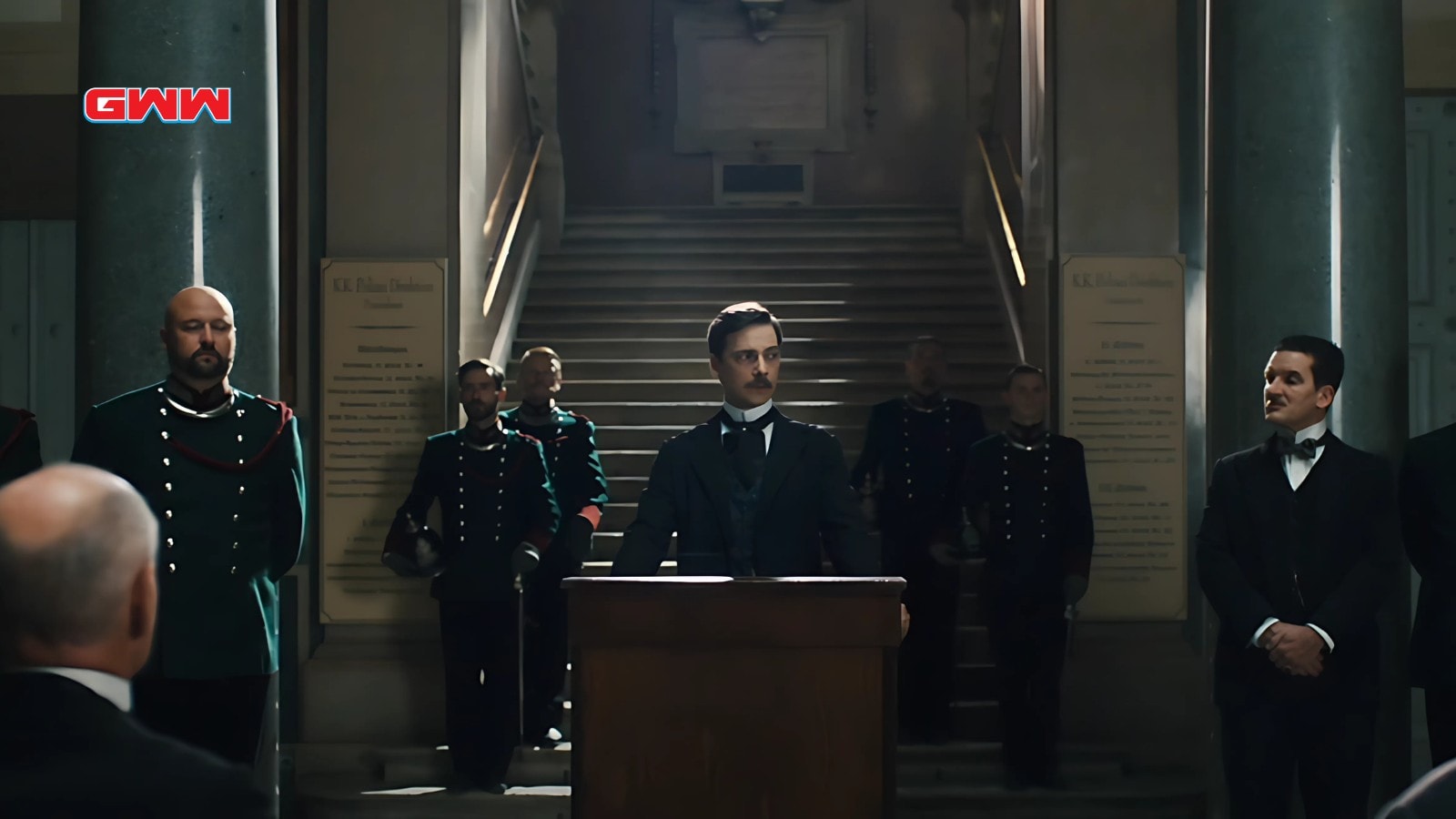 Juergen Maurer at podium during police ceremony, surrounded by uniformed officers