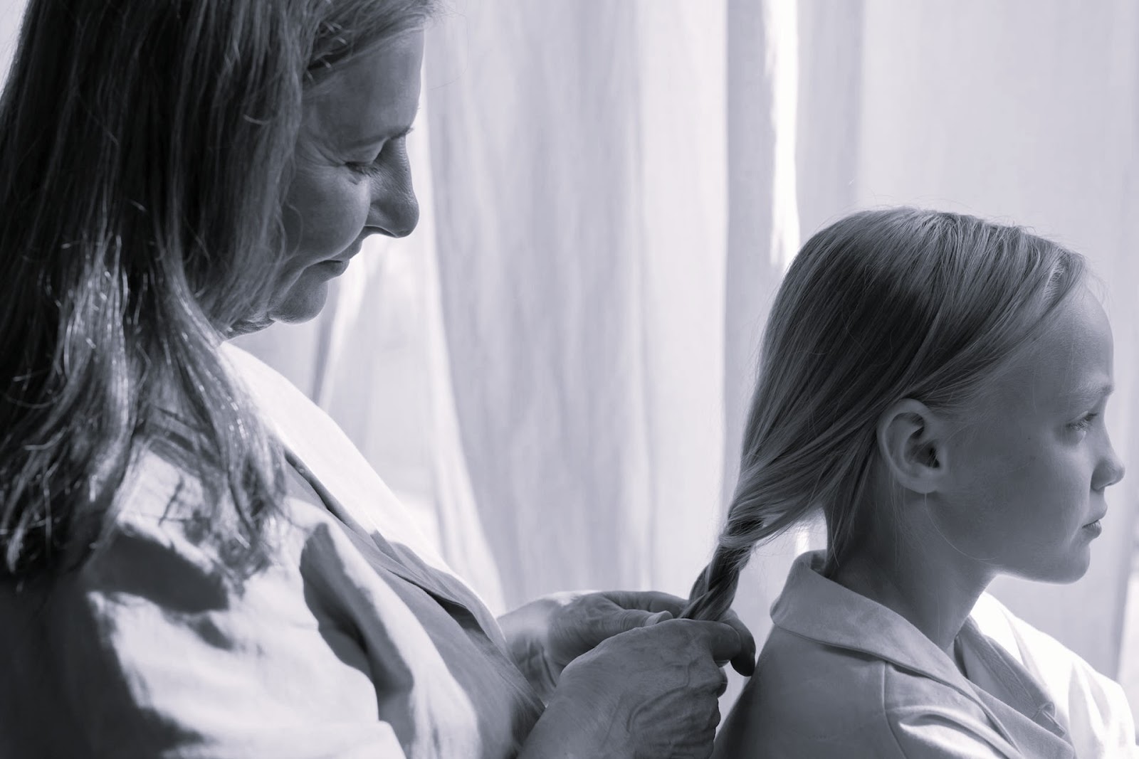 A grandmother braiding her granddaughter's hair | Source: Pexels