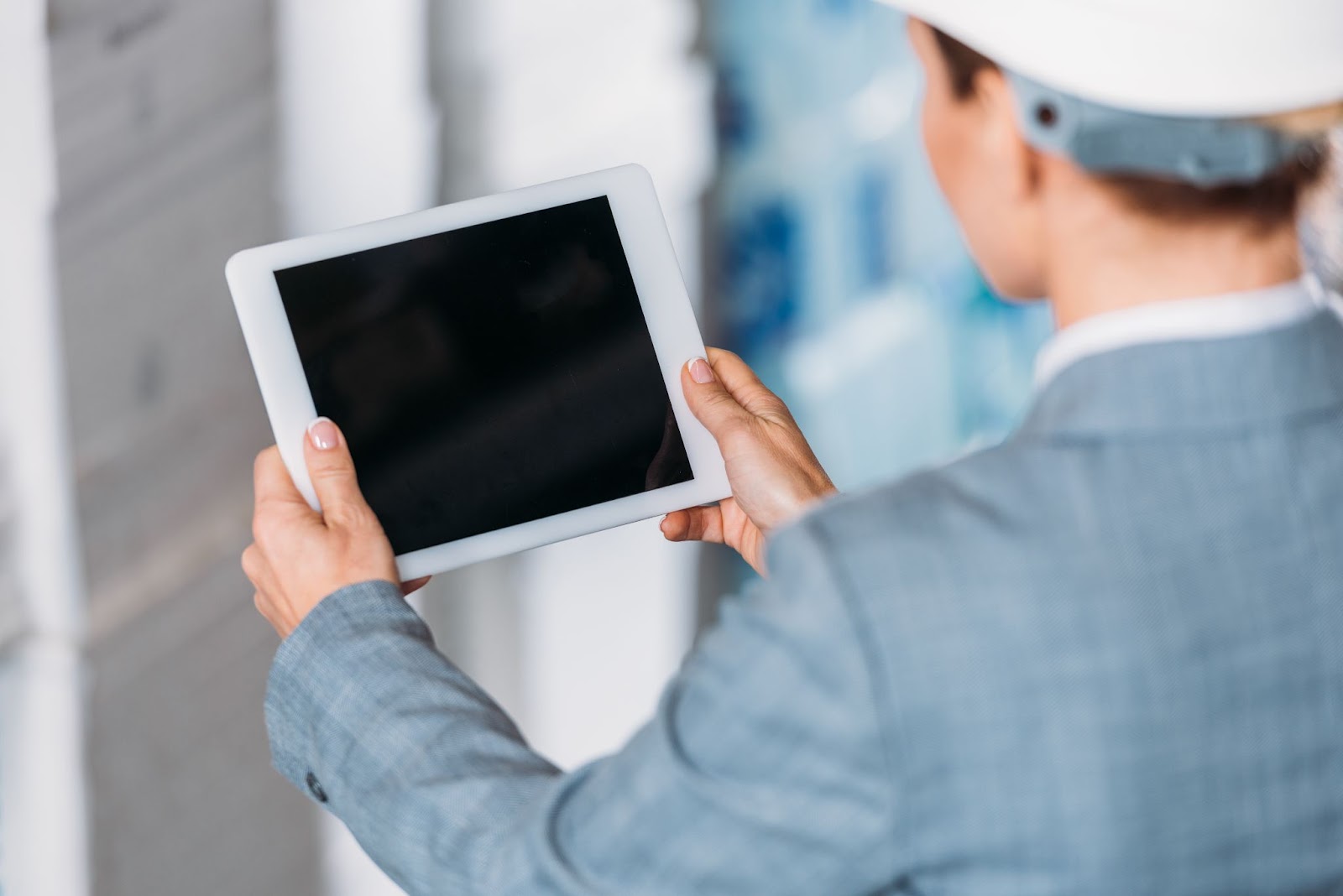 Woman with a hardhat using a tablet. 