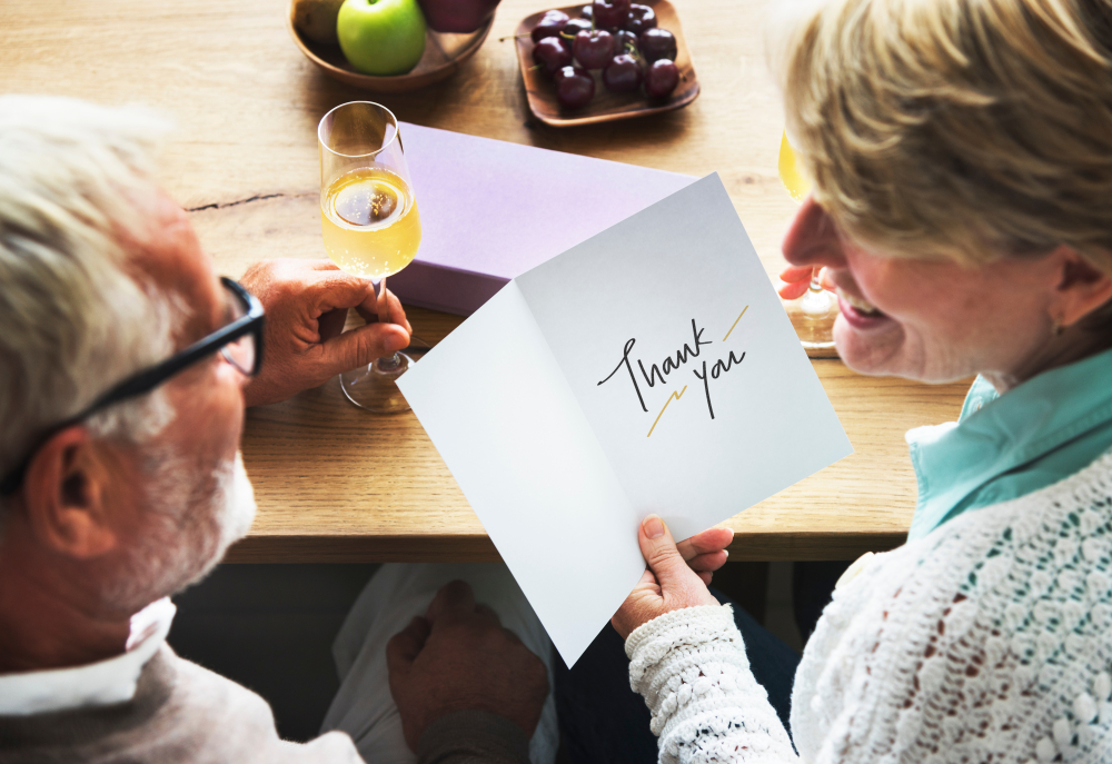 Mature couple reading a thank you card from a friend