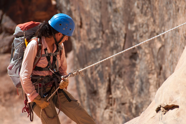 woman absailing down cliff