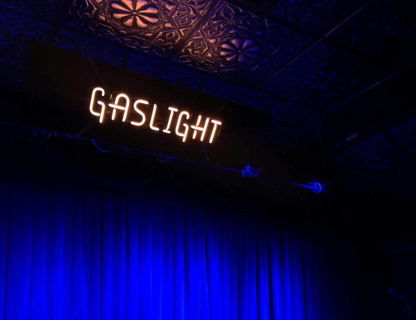 a stage with a blue curtain and a sign that reads gaslight