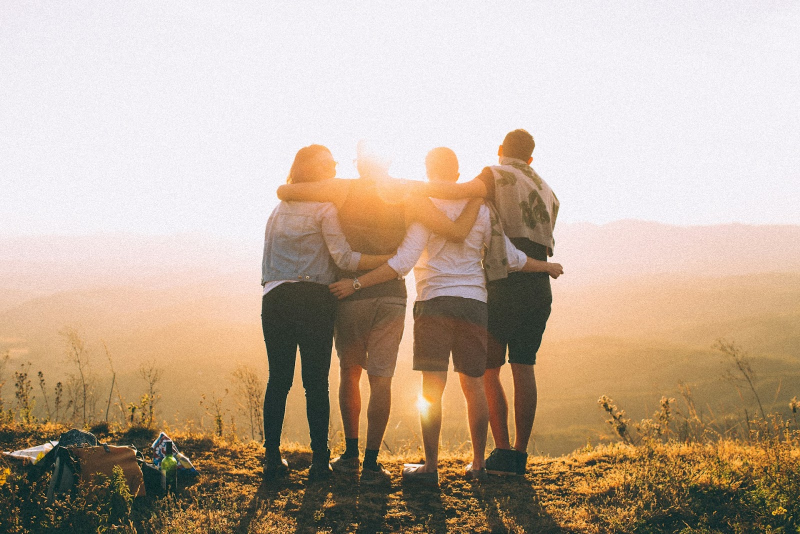 A group of people standing together watching the sunset.