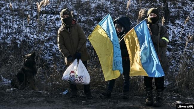 Діти з прапорами України стоять на варті на імпровізованому блокпості поблизу Слов'янська, Донецька область, 11 січня 2023 року